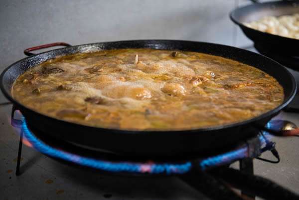 Paella valenciana al fuego en la cocina