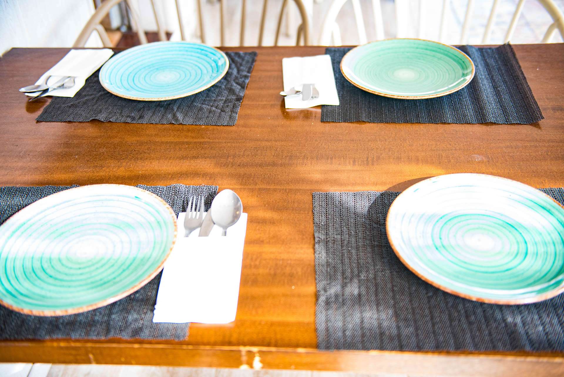 Mesa puesta con platos artesanos en tonos teal